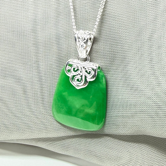A real green jade necklace large pendant that is cushion in shape