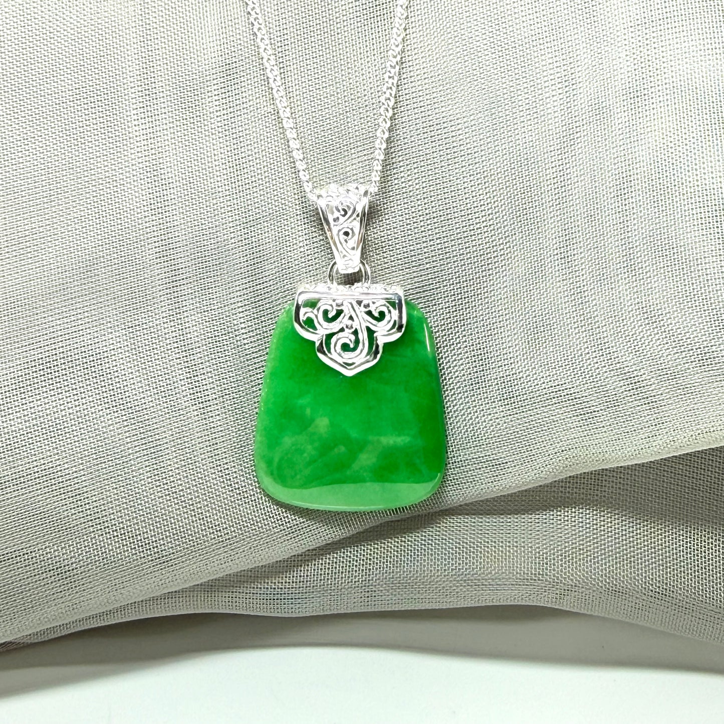 A real green jade necklace large pendant that is cushion in shape