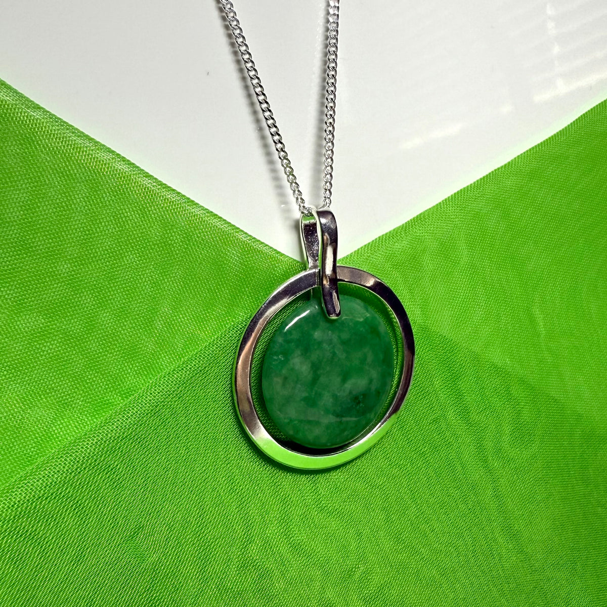 Large silver round shaped dark green real jade necklace with a chain