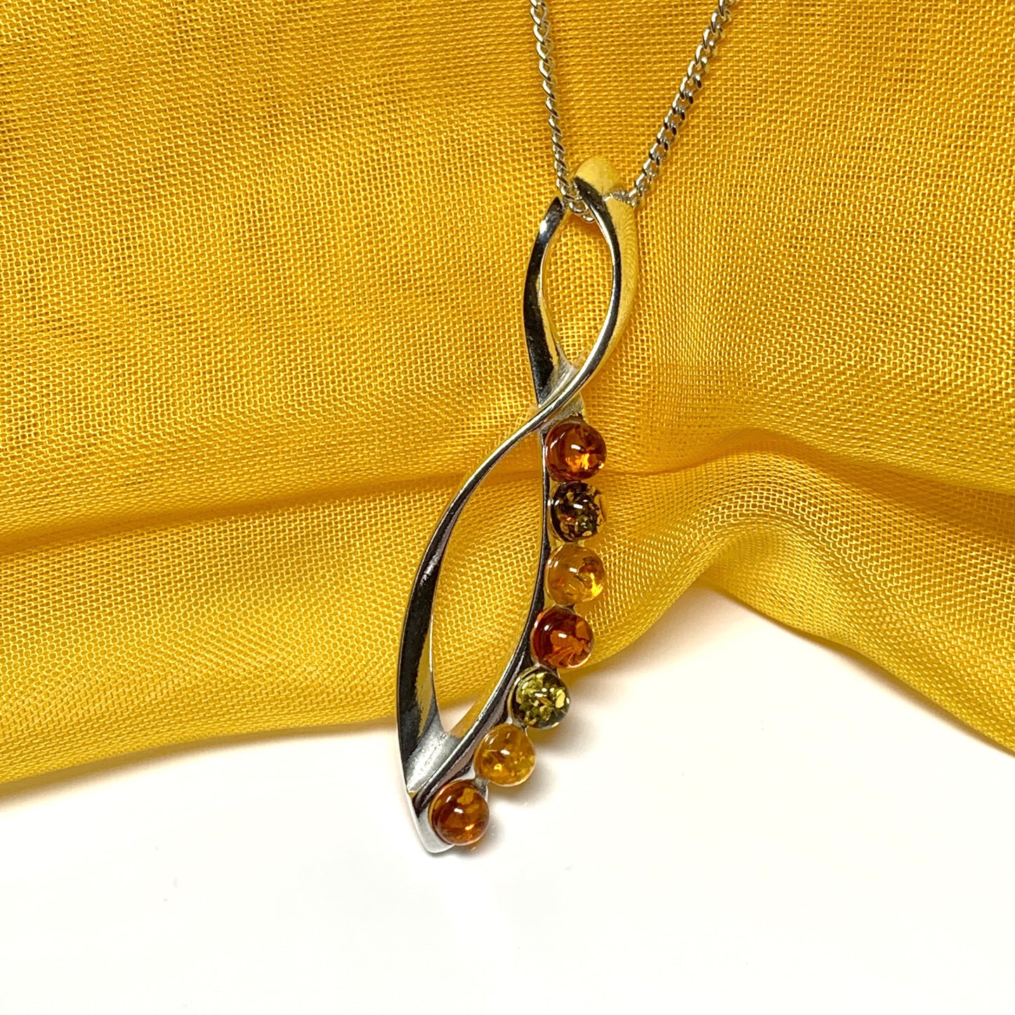 Multi colour amber figure of eight drop sterling silver necklace