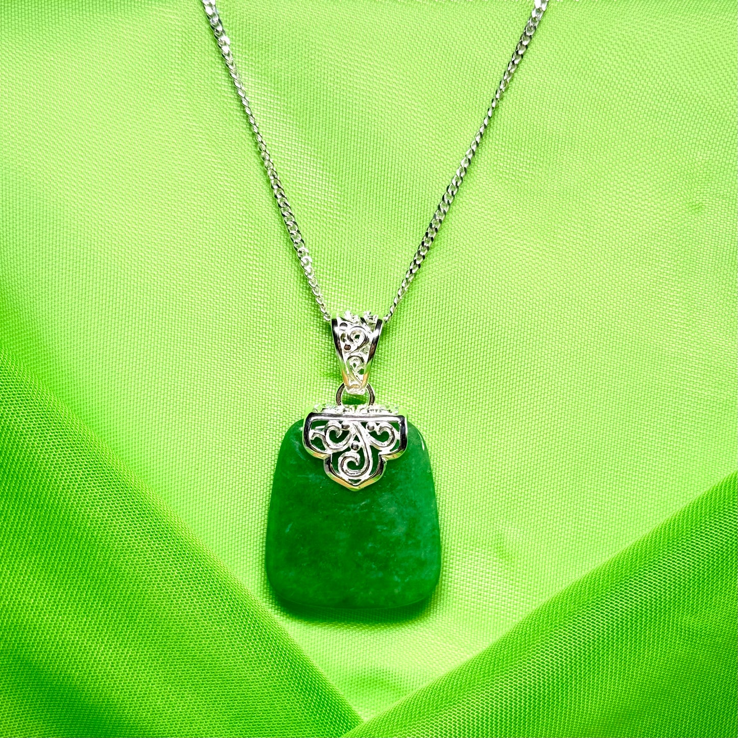 Green pendant necklace on a green fabric background