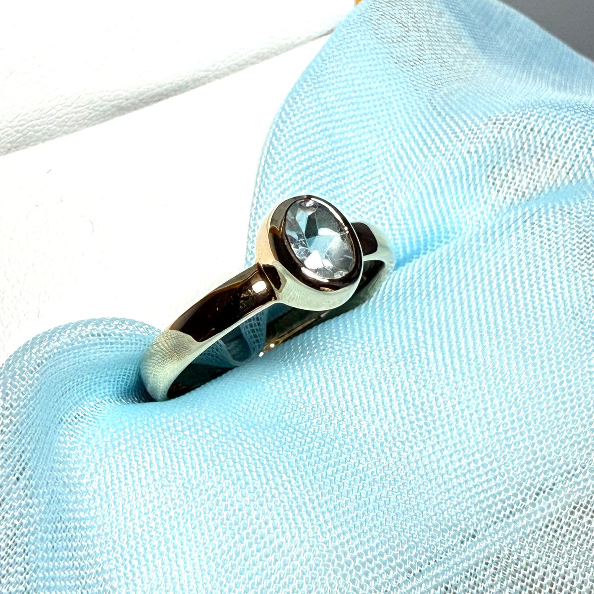 Oval shaped real blue topaz yellow gold dress ring smooth rubbed over setting