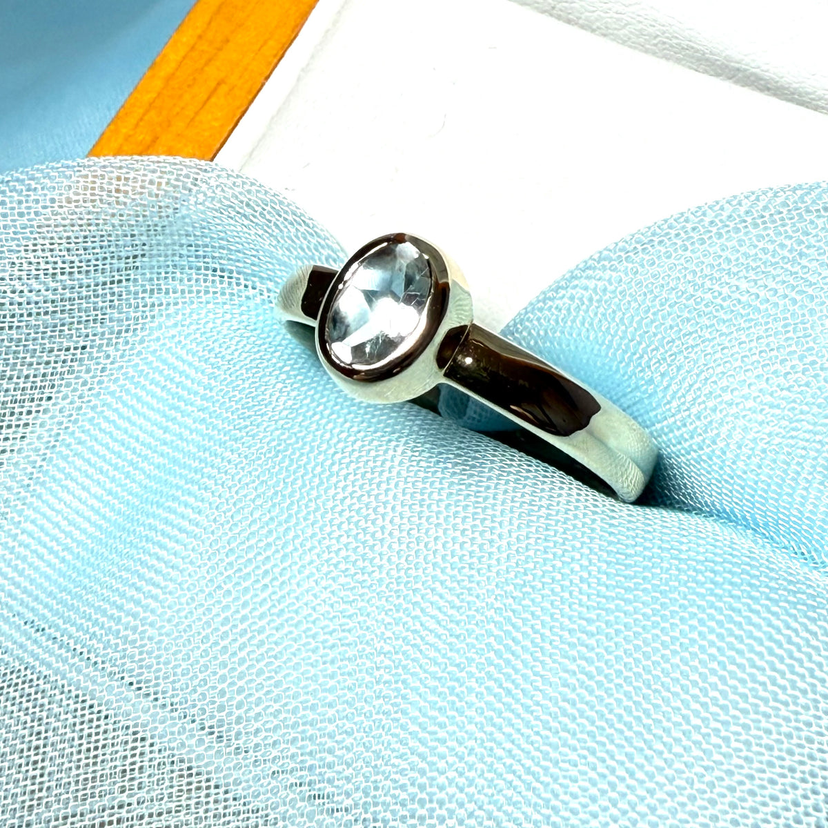 Oval shaped real blue topaz yellow gold dress ring smooth rubbed over setting