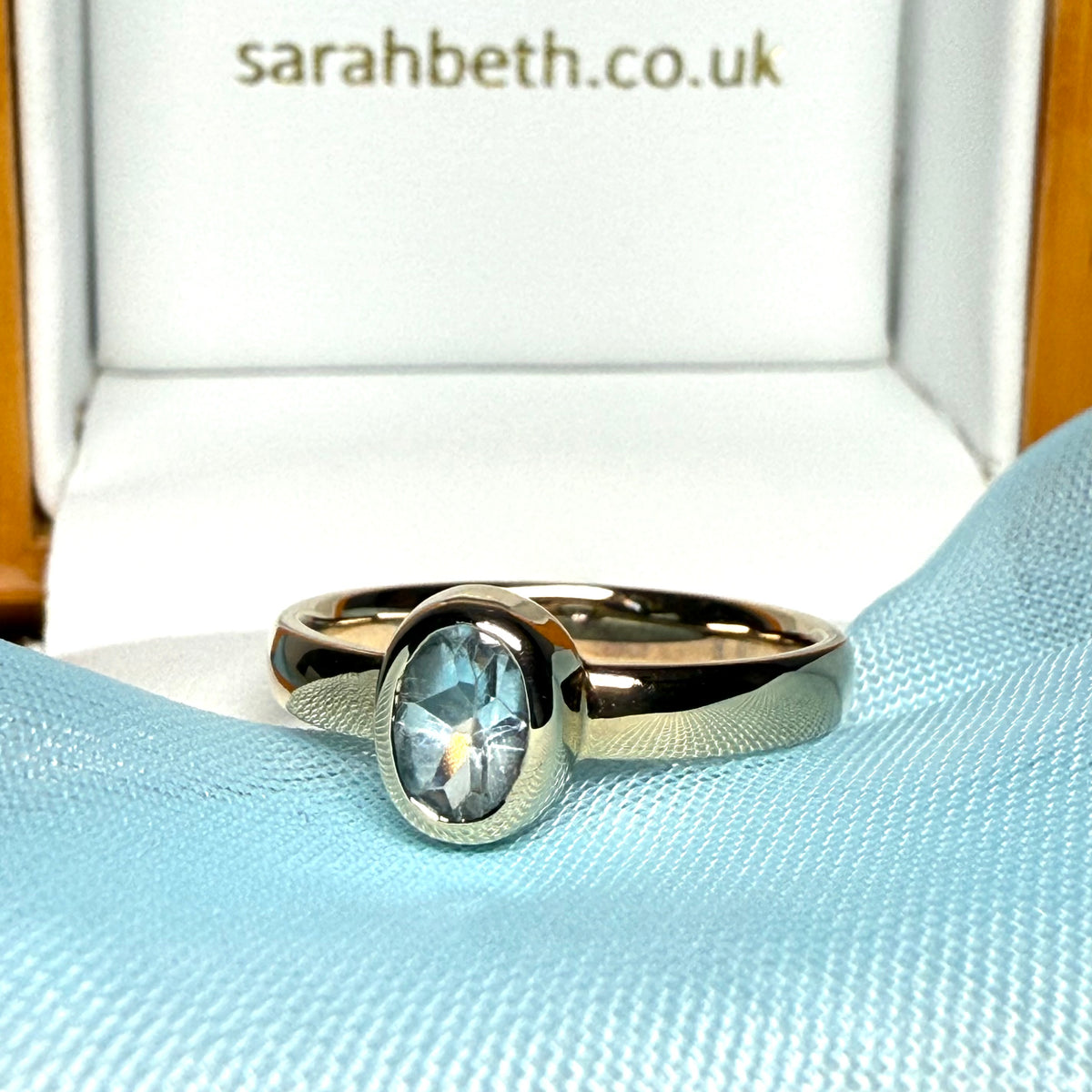 Oval shaped real blue topaz yellow gold dress ring smooth rubbed over setting
