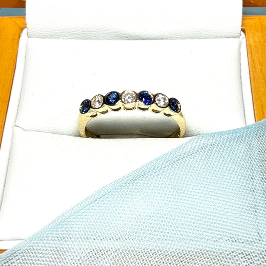 A real blue sapphire and diamond yellow gold eternity ring smooth setting