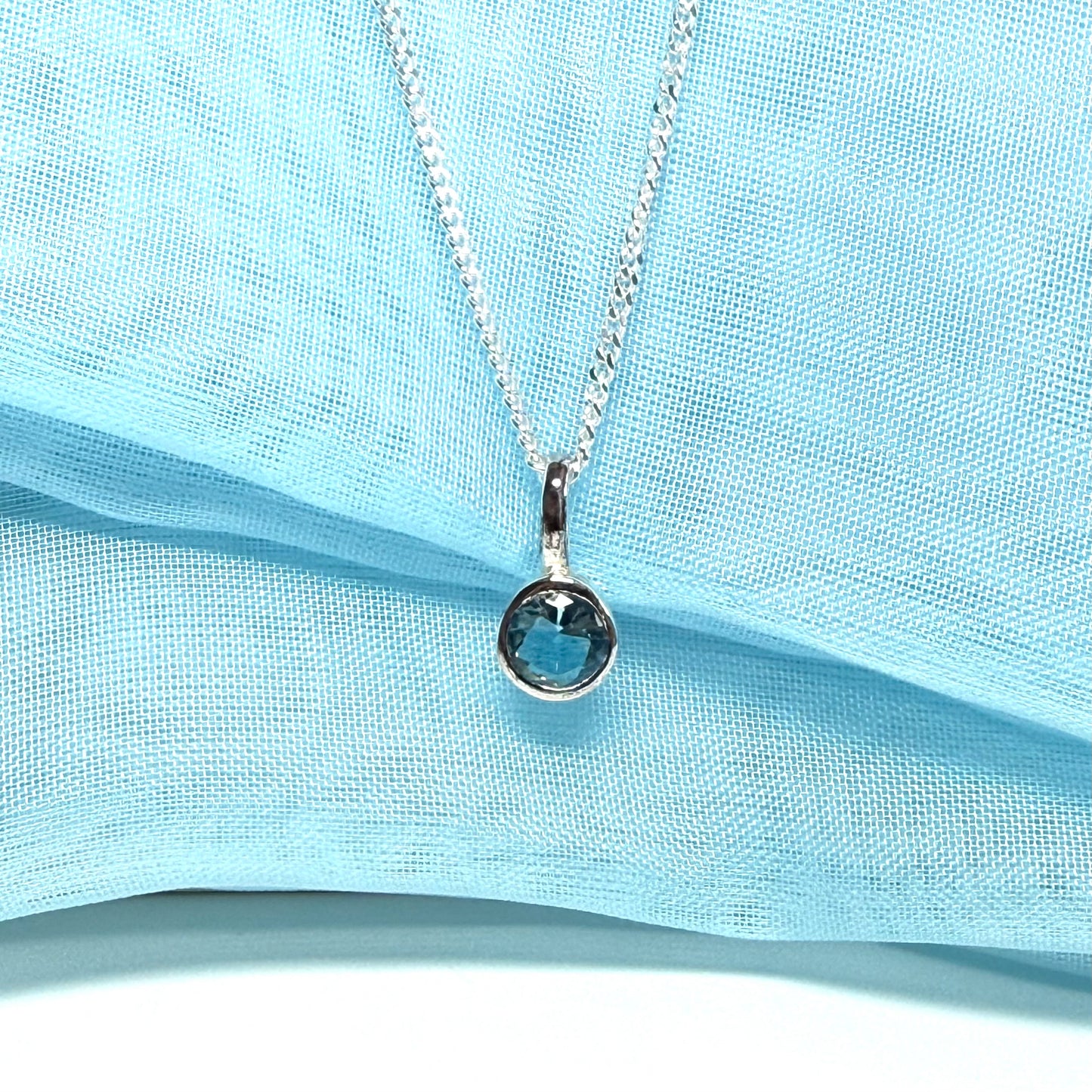 Real blue topaz round sterling silver necklace with a smooth rubbed over pendant