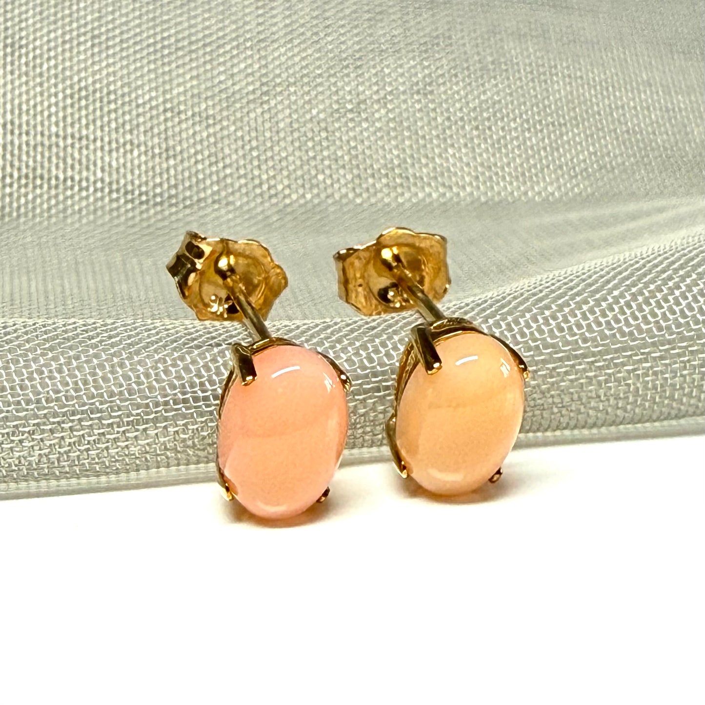 Real coral oval stud earrings yellow gold within a simple four claw setting
