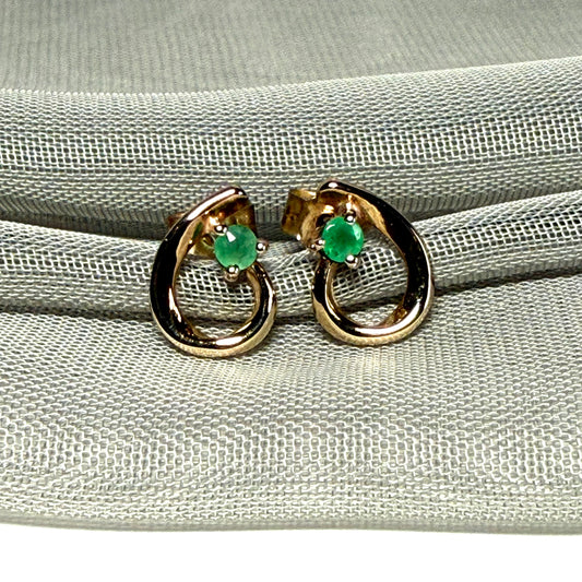 Real emerald pair of stud earrings with a fancy swirl design