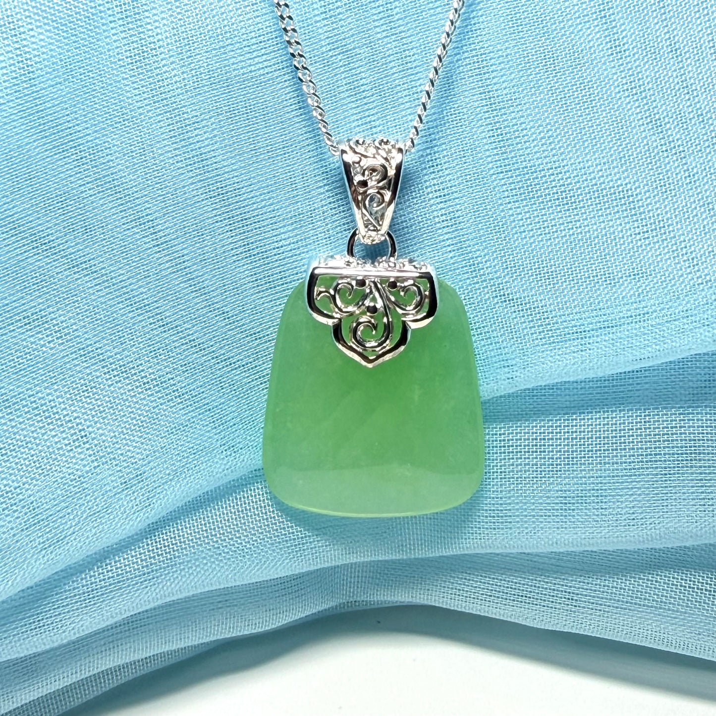 Real green jade necklace with a large shaped and patterned top pendant
