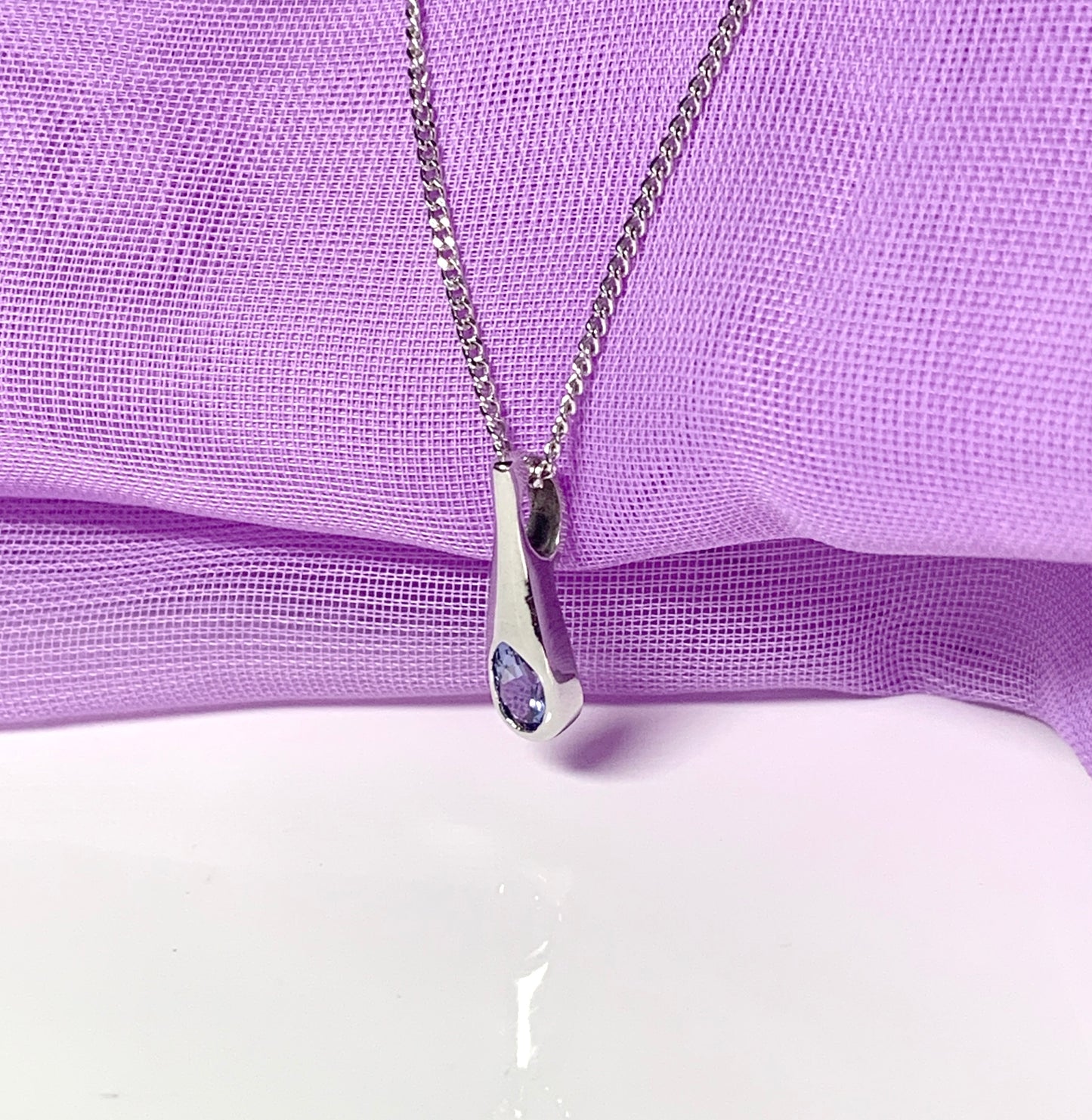 Real tanzanite white gold necklace rubbed over setting