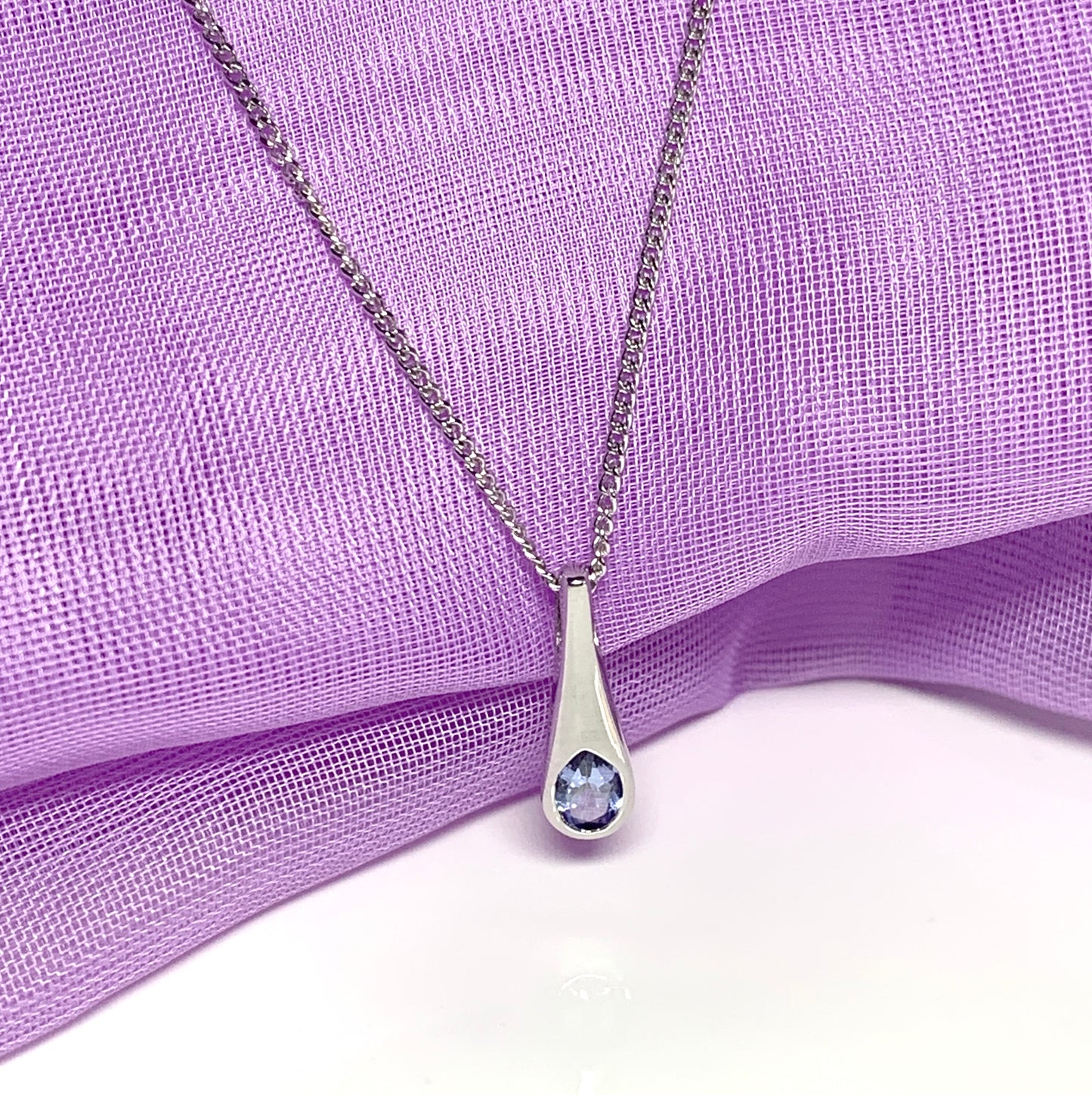 Real tanzanite white gold necklace rubbed over setting