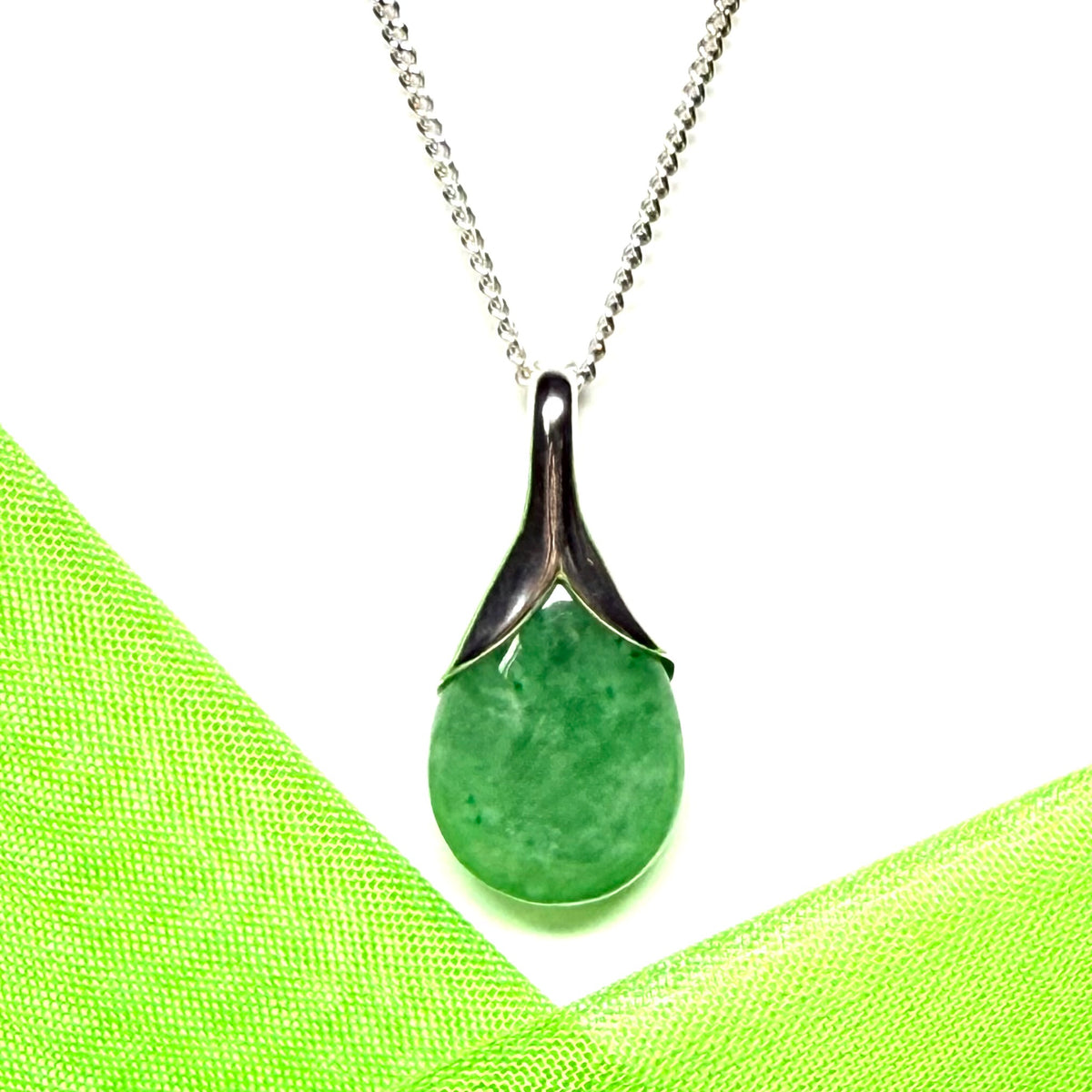 A real green jade necklace in a teardrop or pear shaped including a solid chain