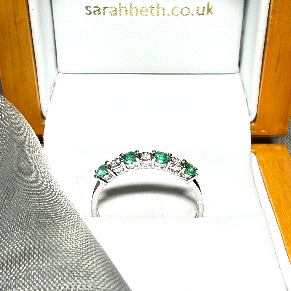 A real emerald and diamond white gold eternity ring claw setting