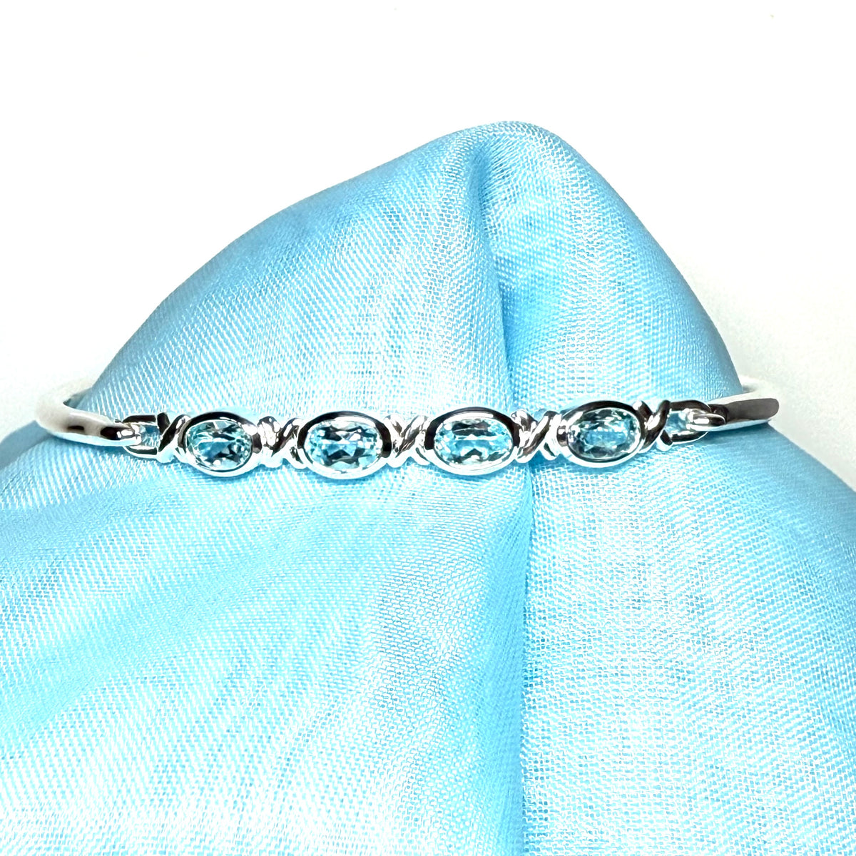 Sterling silver four oval blue topaz kiss bangle