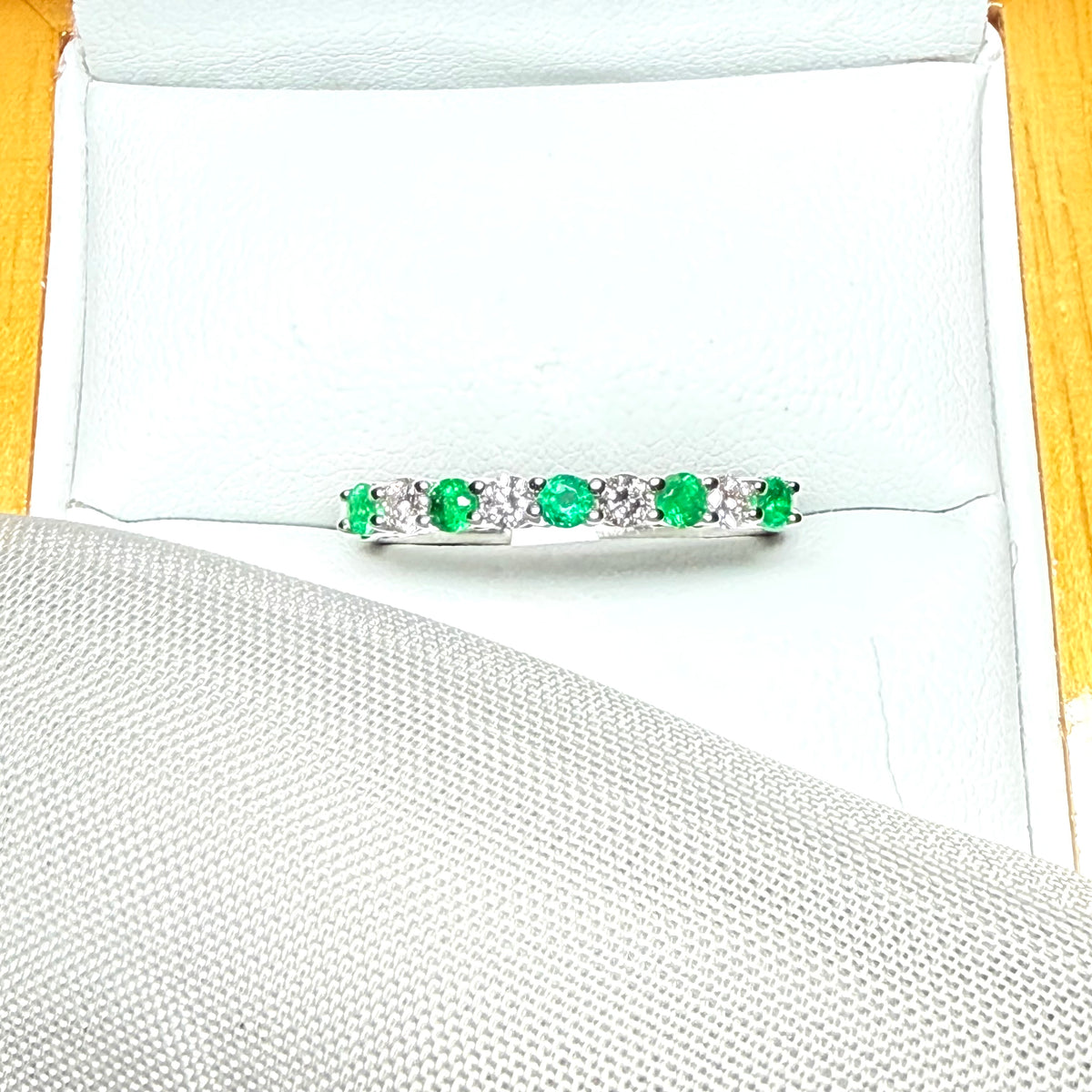 A stunning real emerald and diamond white gold eternity ring claw setting