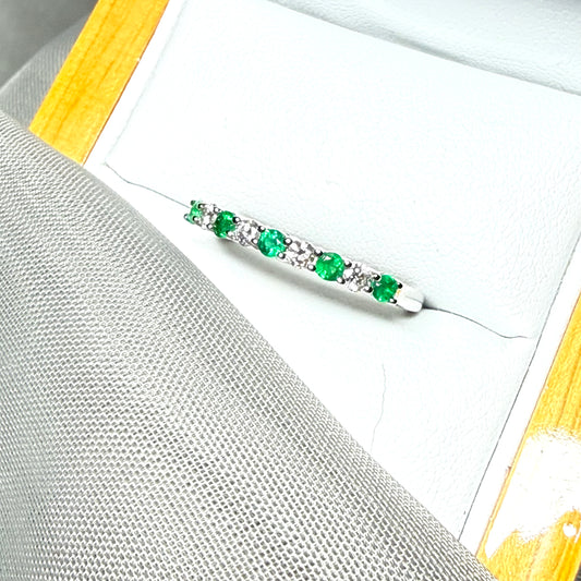 A stunning real emerald and diamond white gold eternity ring claw setting