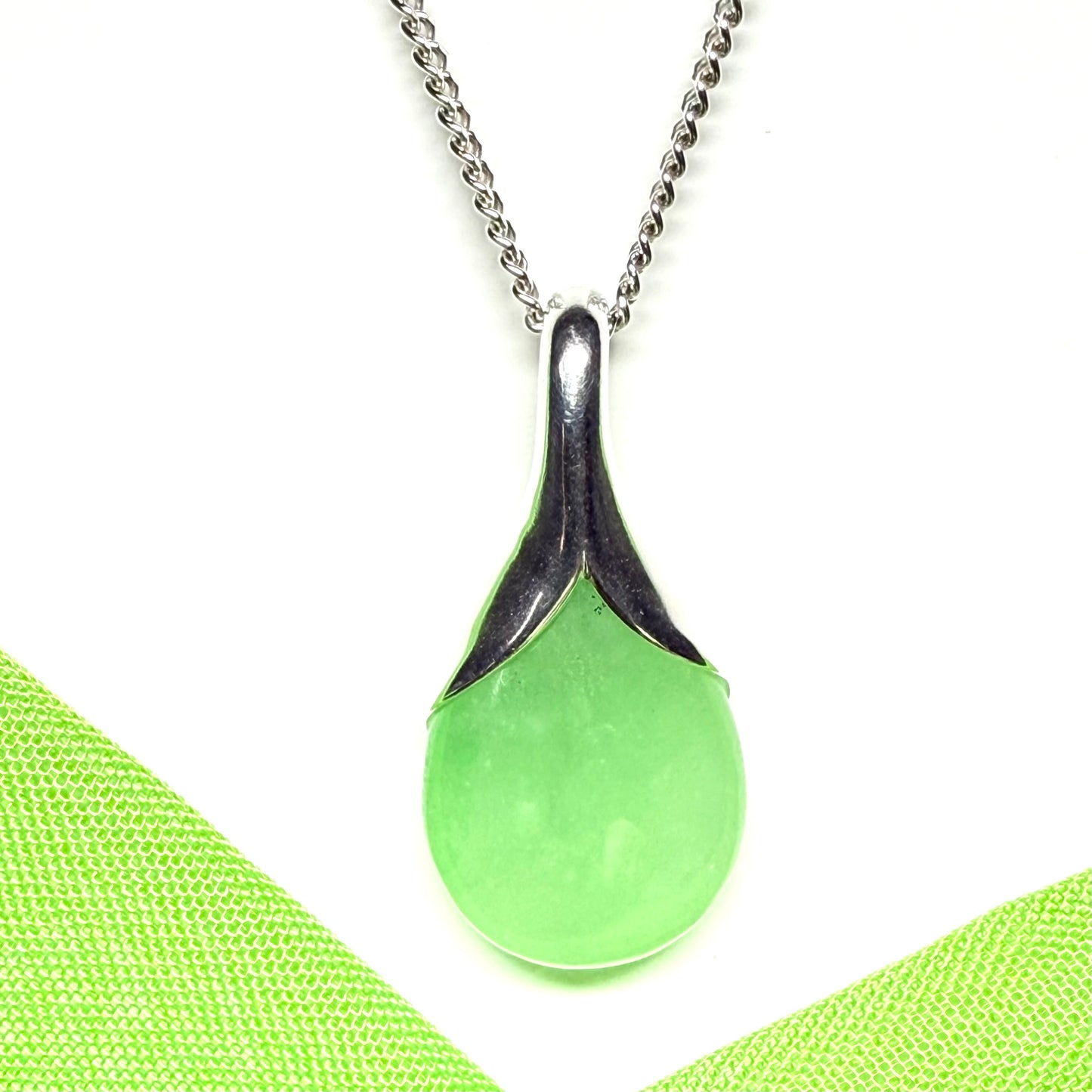 A stunning real green jade necklace in a teardrop or a pear shape including a solid curb chain