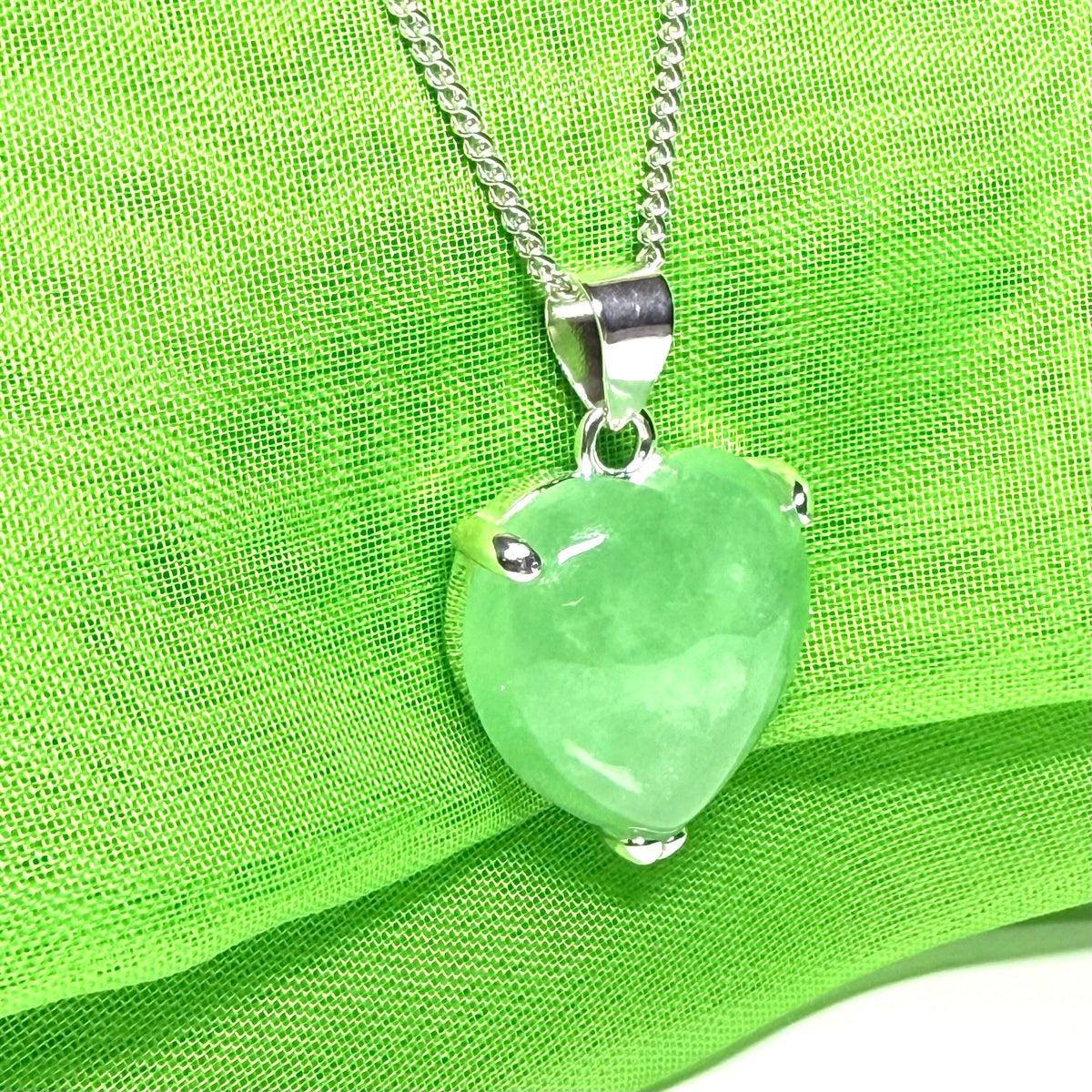 A stunning real light green jade necklace heart shaped sterling silver pendant