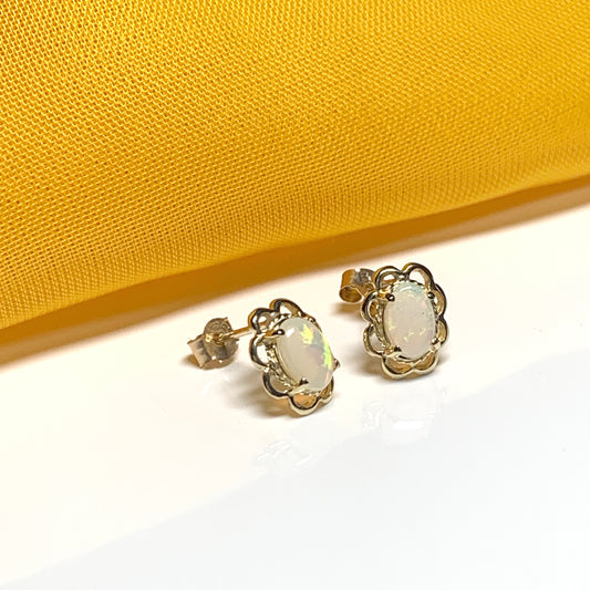 Yellow gold real opal oval stud earrings with a fancy scrolled edging