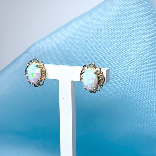 Yellow gold oval opal stud earrings with a pierced setting