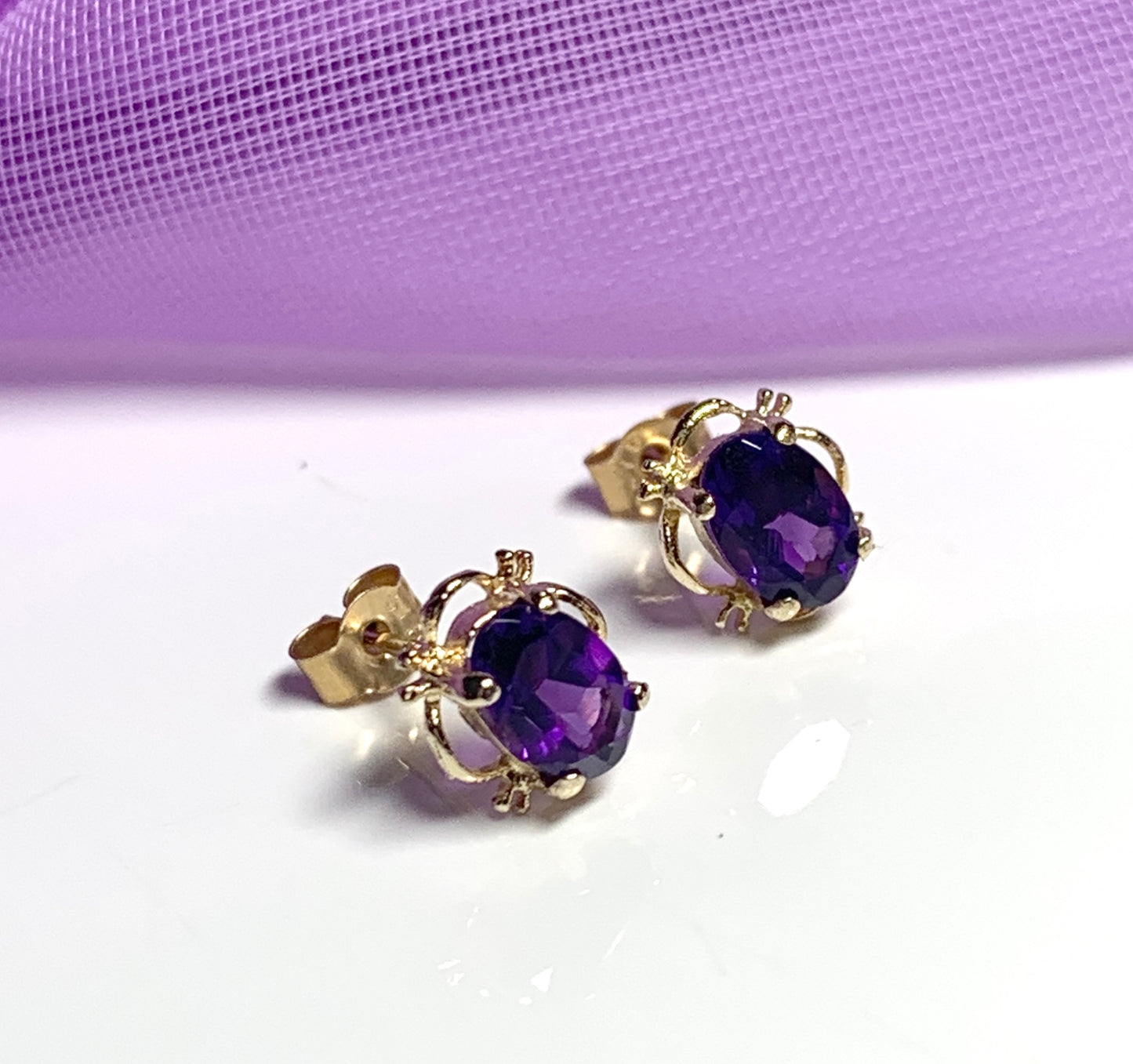 Yellow gold oval purple amethyst stud earrings with fancy edging