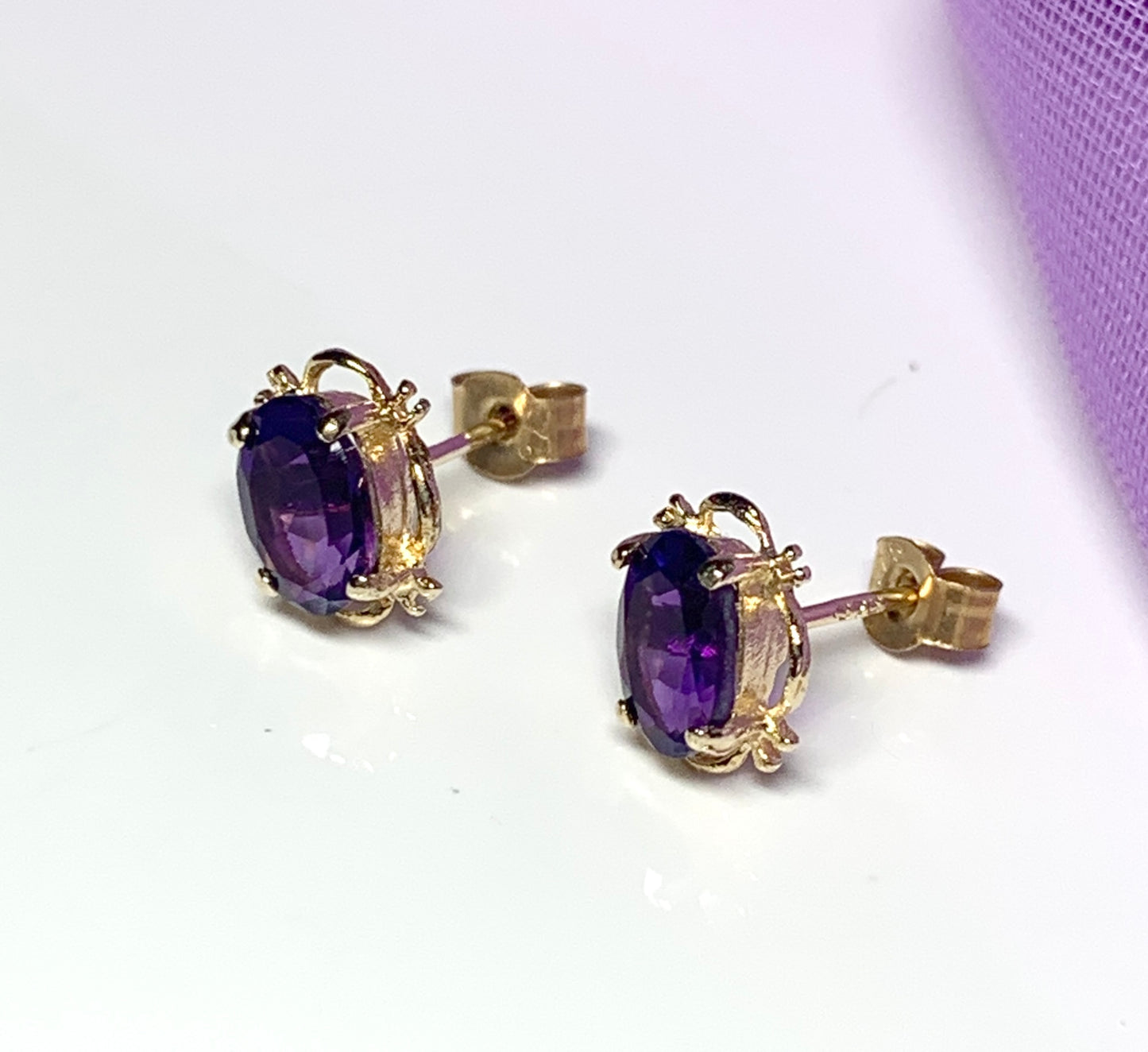 Yellow gold oval purple amethyst stud earrings with fancy edging