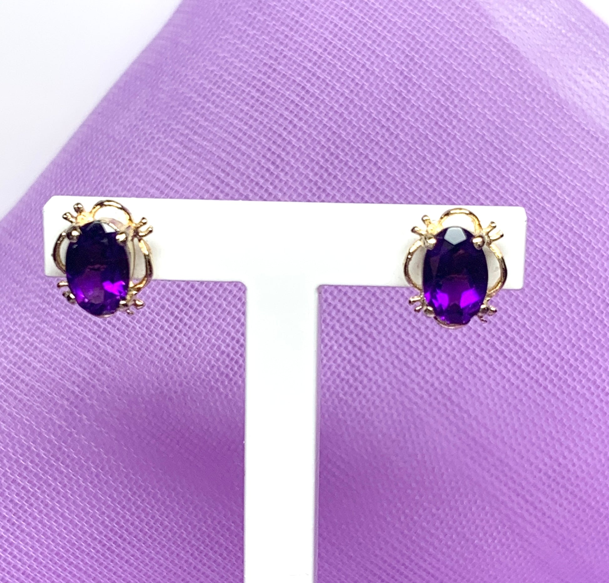 Yellow gold oval purple amethyst stud earrings with fancy edging