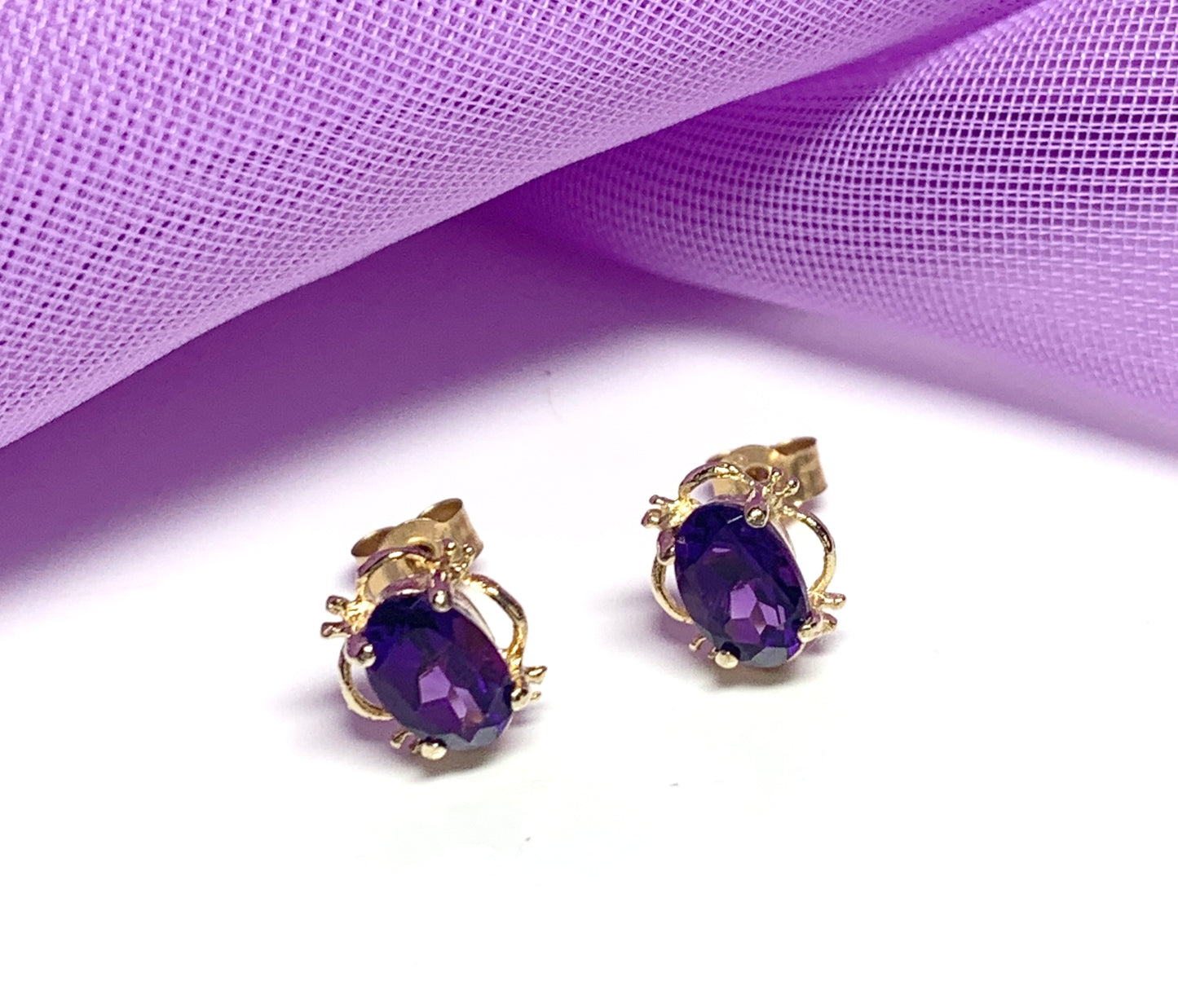 Yellow gold oval purple amethyst stud earrings with fancy edging