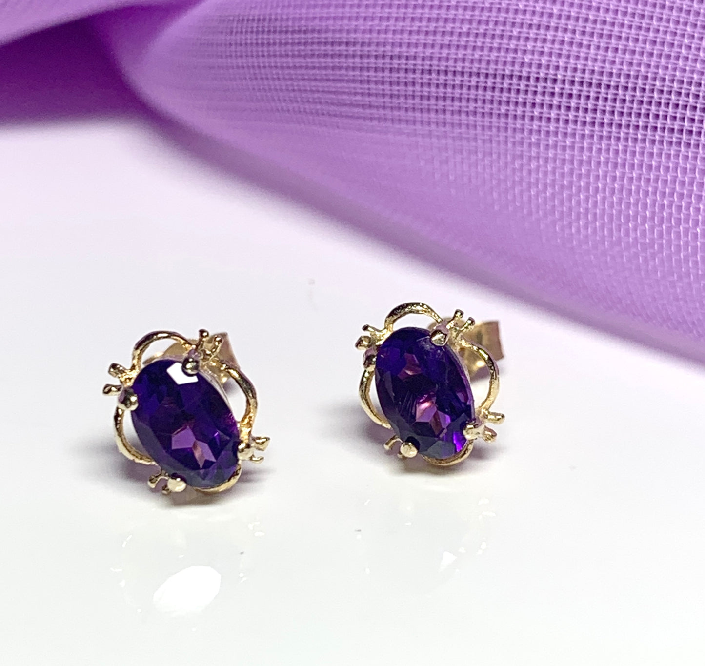 Yellow gold oval purple amethyst stud earrings with fancy edging