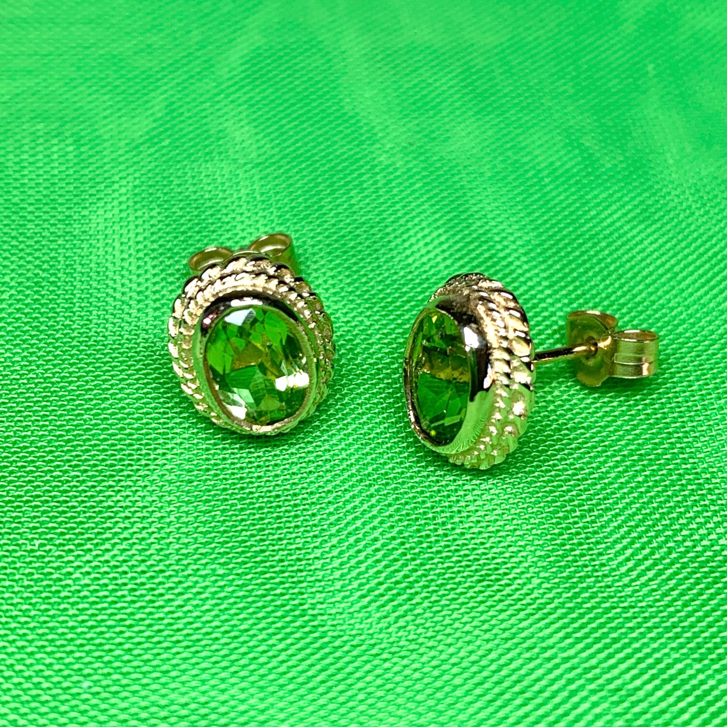 Oval shaped peridot yellow gold rope edged stud earrings