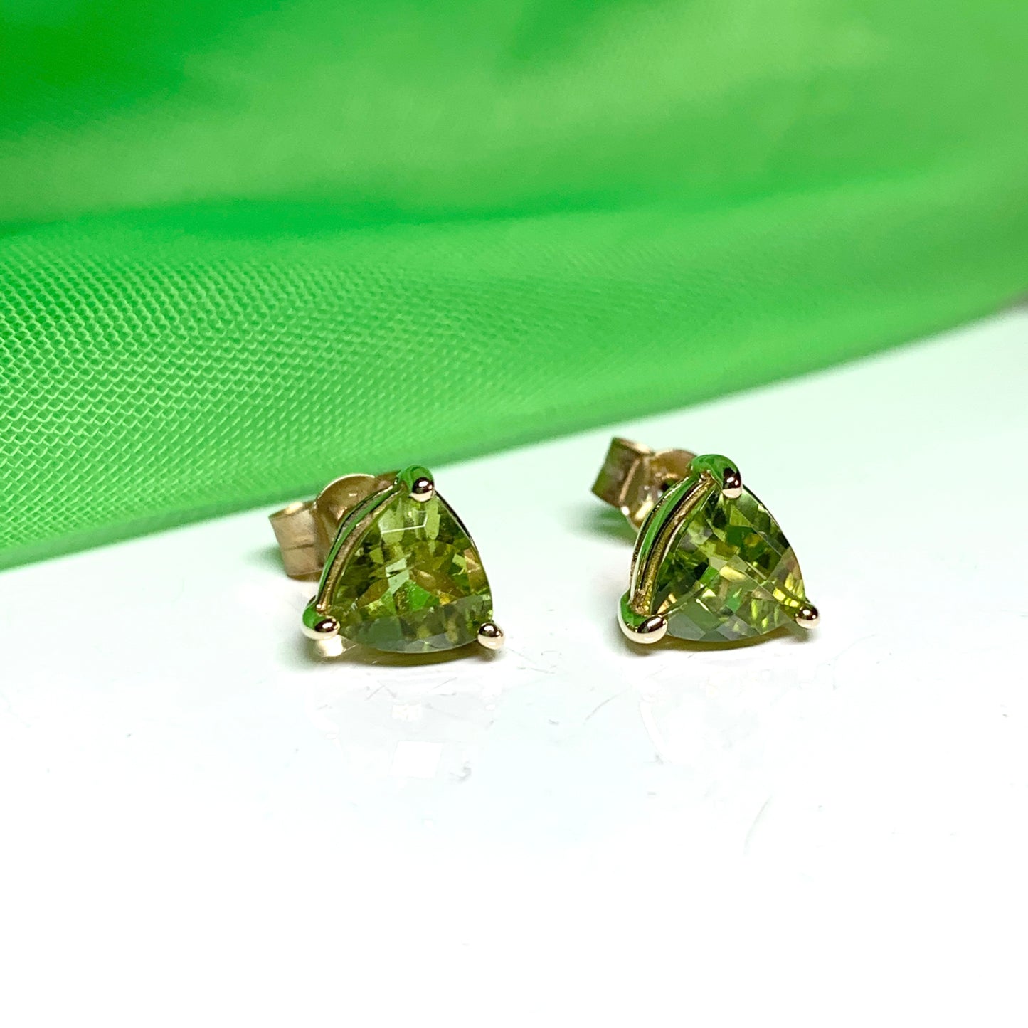 Trillion shaped peridot yellow gold stud earrings