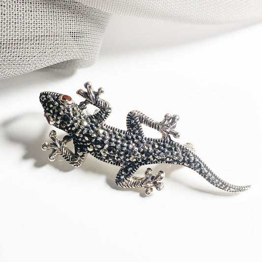 A sterling silver real marcasite gecko brooch with real garnet eyes