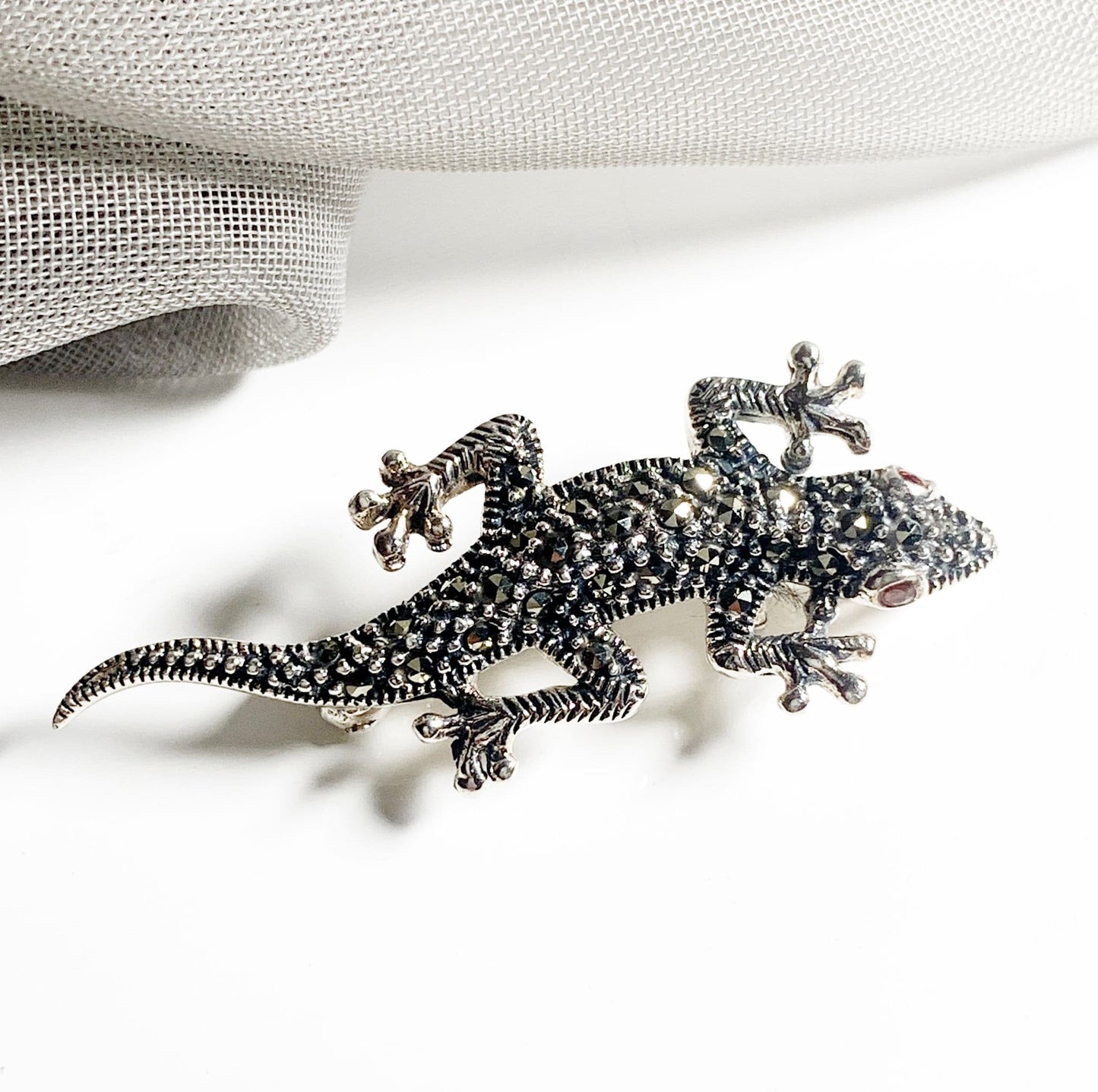 A sterling silver real marcasite gecko brooch with real garnet eyes
