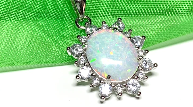 pretty opal pendant set in a oval cluster of cubic zirconia