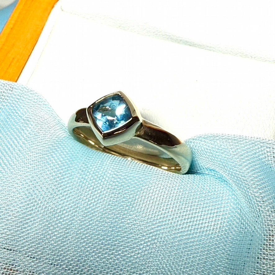 Blue topaz ladies dress ring yellow gold with a smooth rubbed over setting