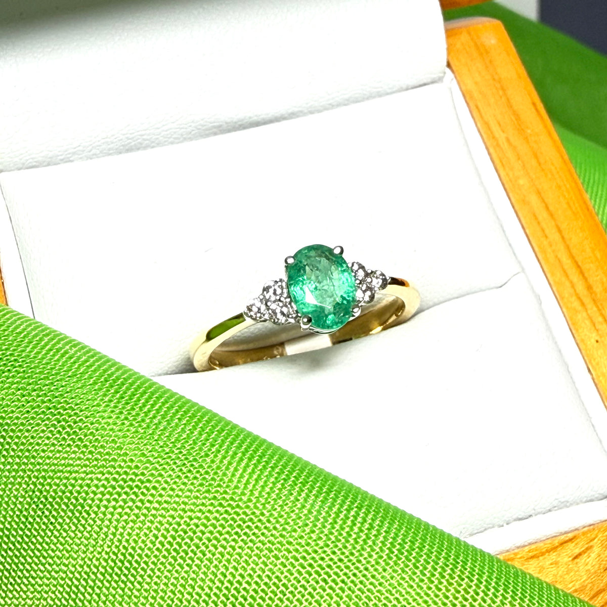 0.70 carat real green emerald and diamond 18 carat yellow gold oval trilogy dress ring