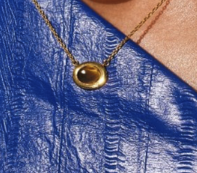 A Real Tiger Eye oval shaped necklace sterling silver gold plated on the neck