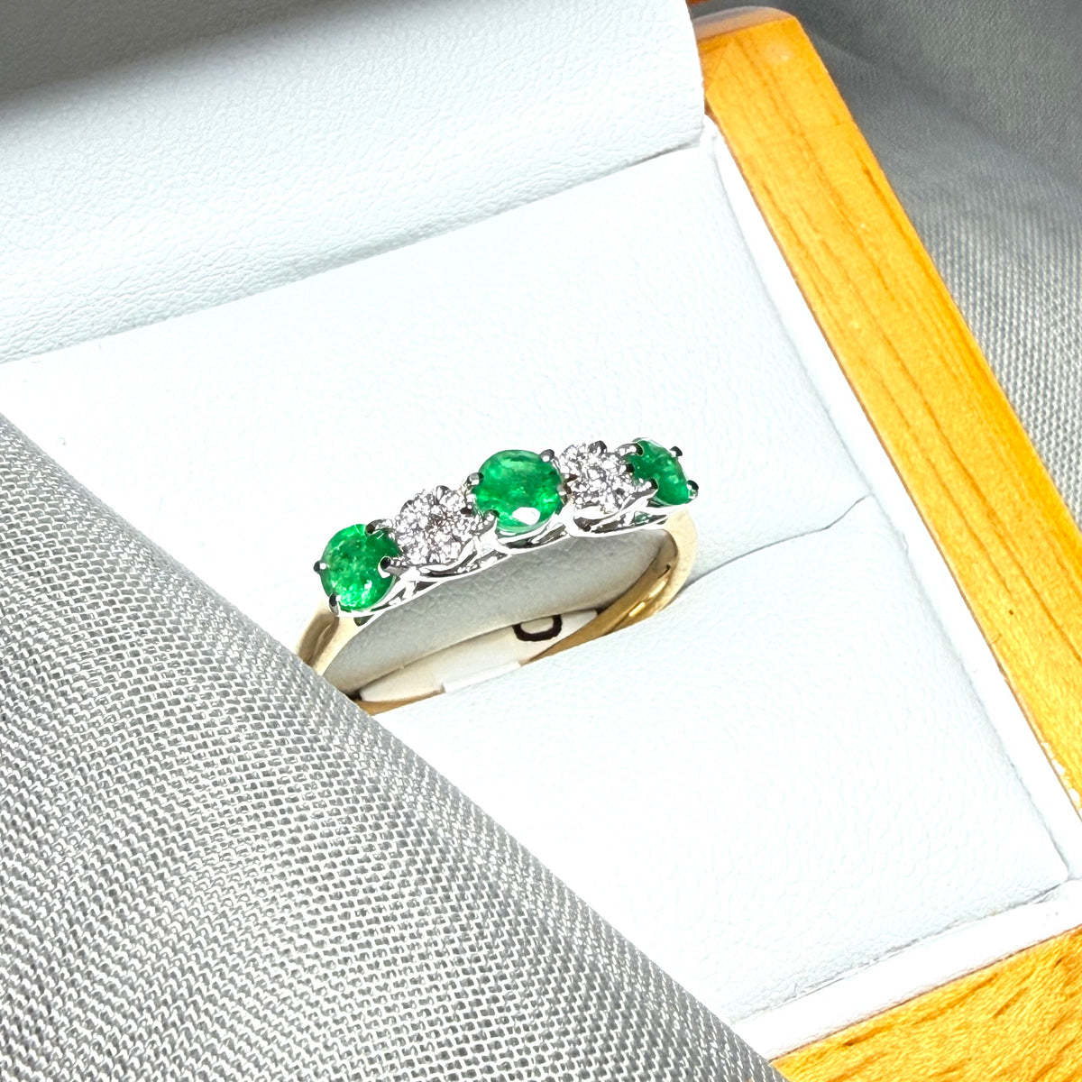 Real emerald and diamond yellow gold eternity ring claw setting