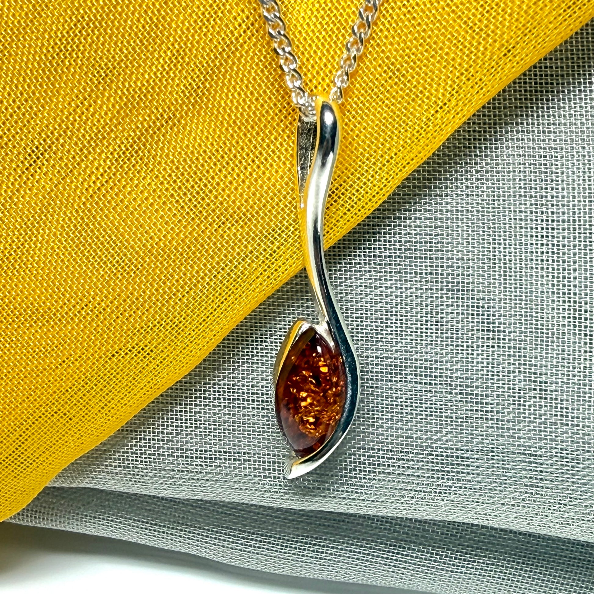 A Sterling silver real amber marquise shaped necklace swirled pendant