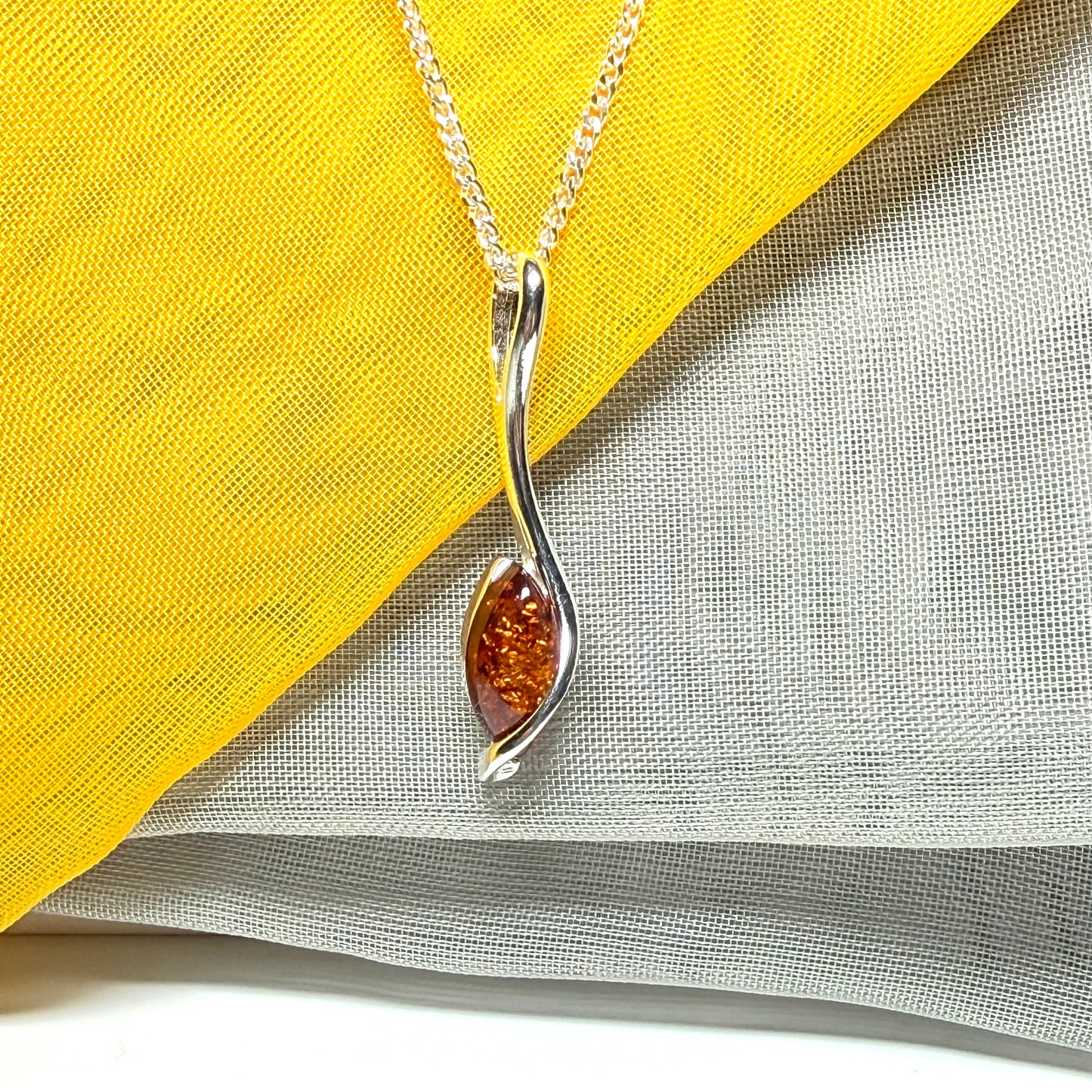 A Sterling silver real amber marquise shaped necklace swirled pendant