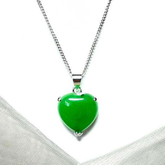 Real green jade heart-shaped pendant on a silver chain against a white background