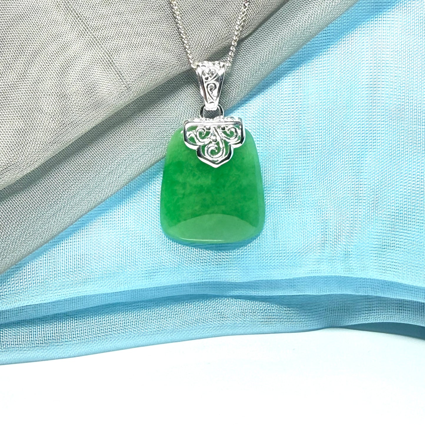 A stunning real green jade necklace with a large shaped and patterned pendant
