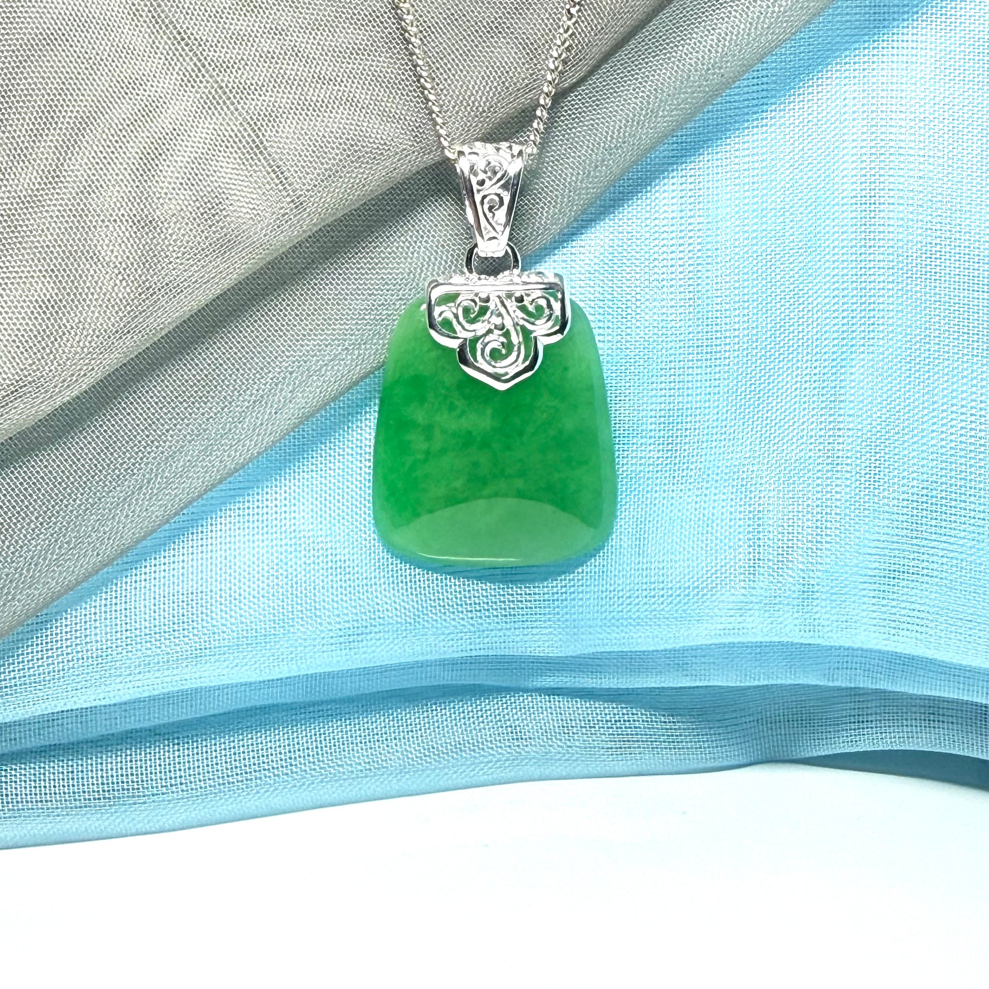 A stunning real green jade necklace with a large shaped and patterned pendant