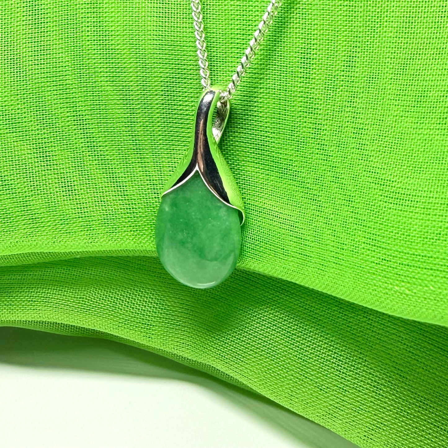 A gorgeous real green jade necklace in a tear drop or pear shaped with a chain as well