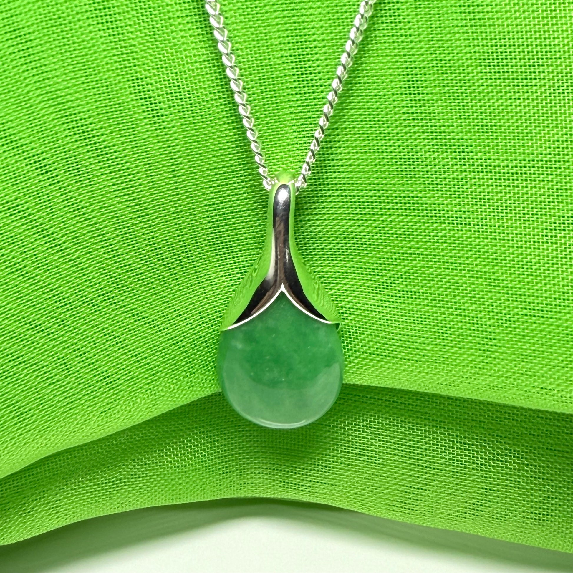 A gorgeous real green jade necklace in a tear drop or pear shaped with a chain as well