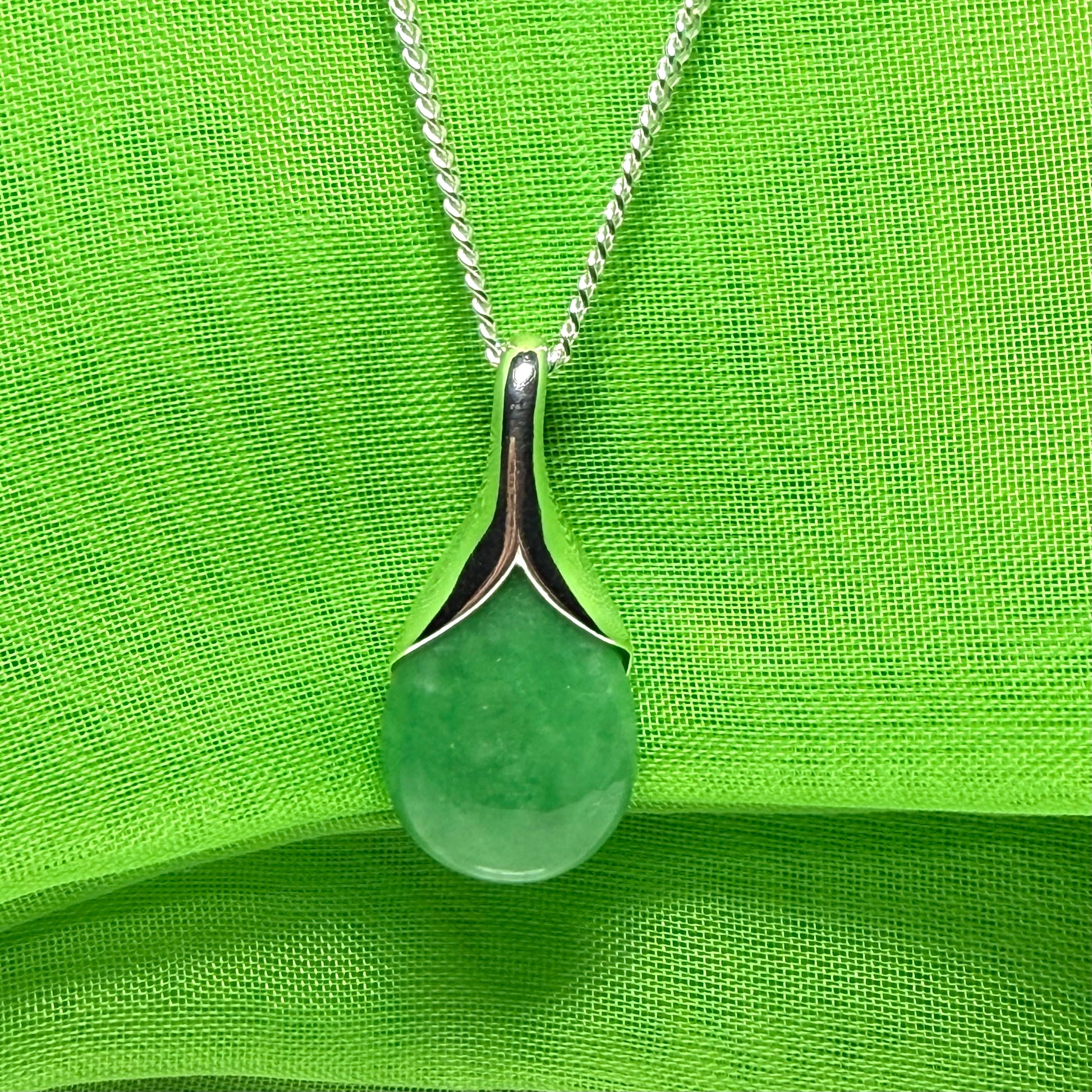 A gorgeous real green jade necklace in a tear drop or pear shaped with a chain as well