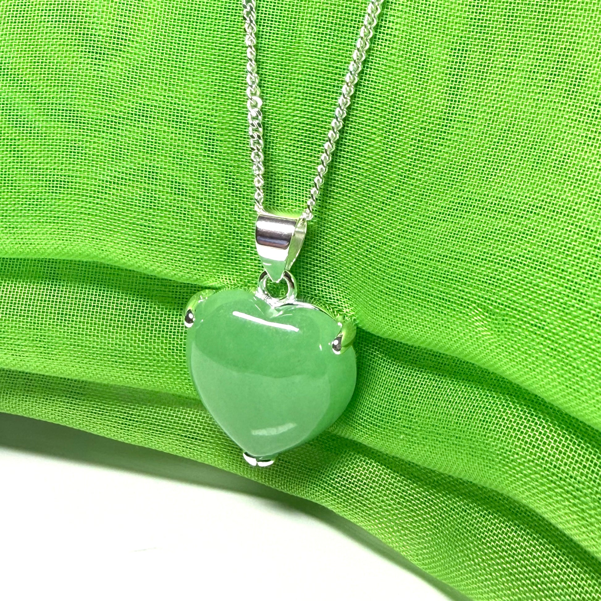 A green real jade pendant necklace heart shape sterling silver with a chain included