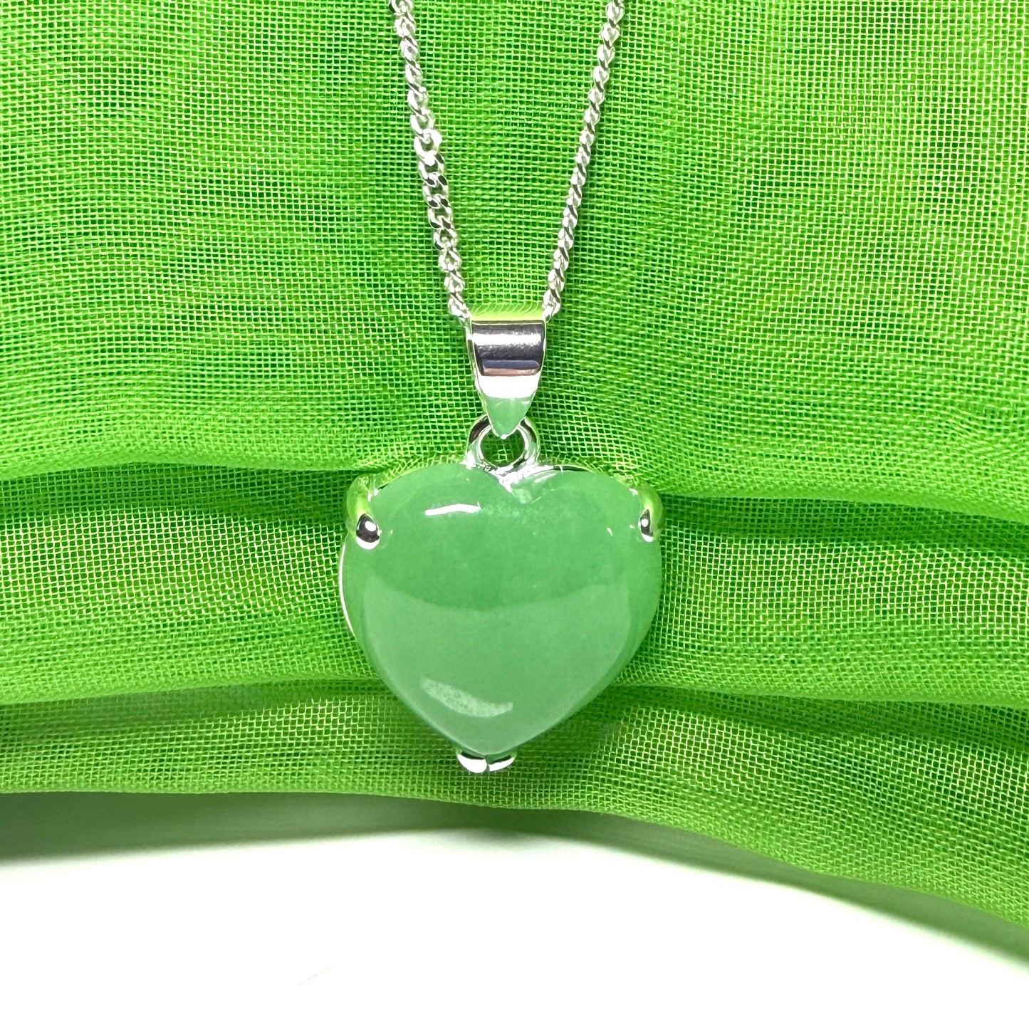 A green real jade pendant necklace heart shape sterling silver with a chain included
