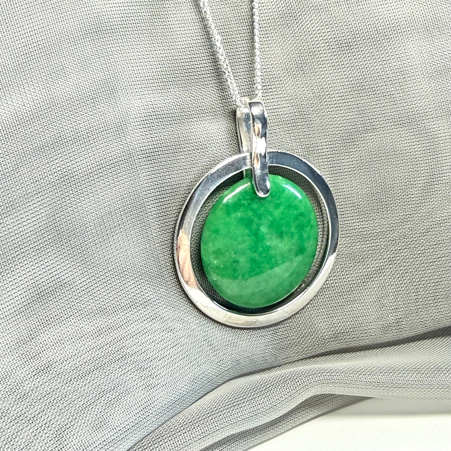A large sterling silver round shaped green real jade necklace halo style, a stunning and timeless pendant design