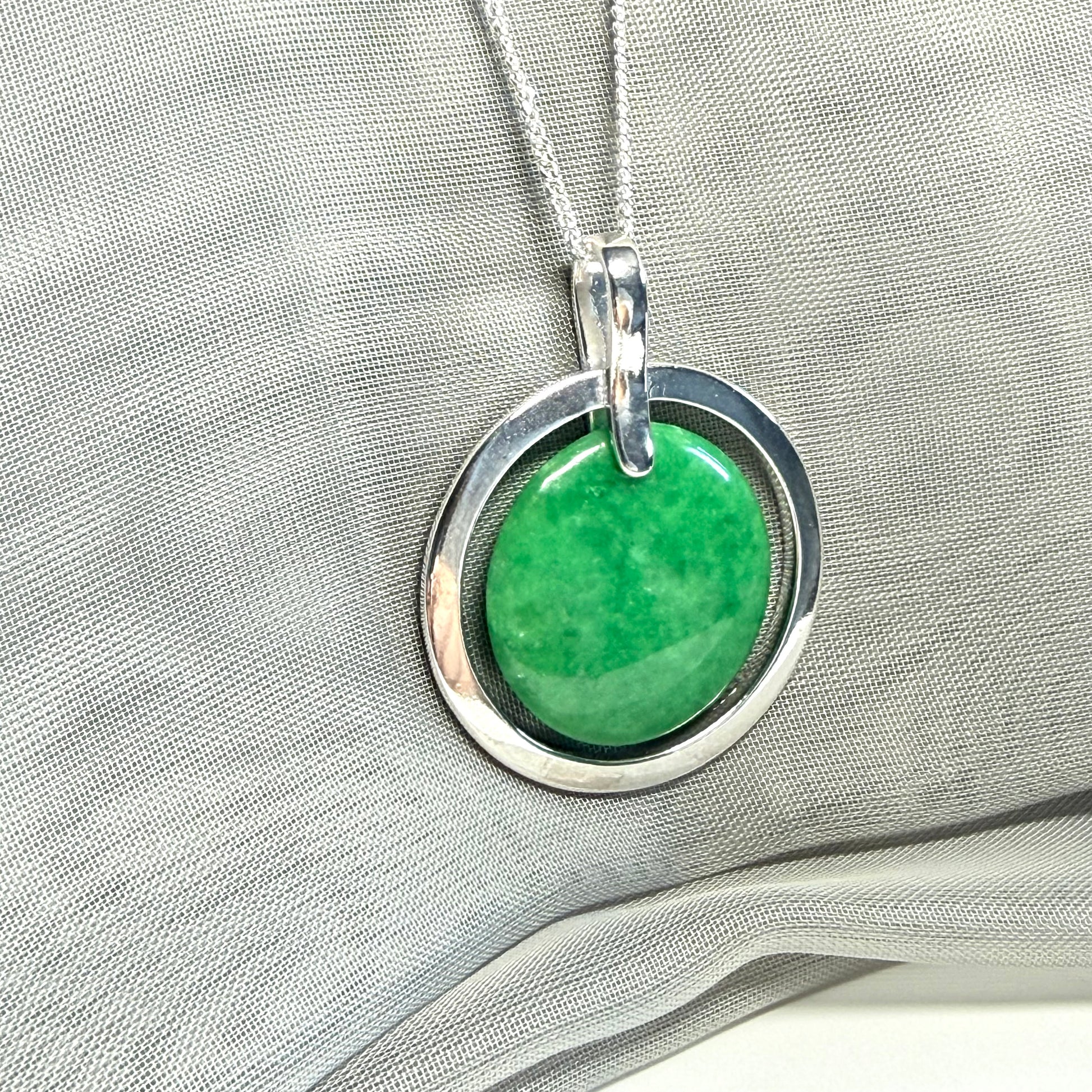 A large sterling silver round shaped green real jade necklace halo style, a stunning and timeless pendant design